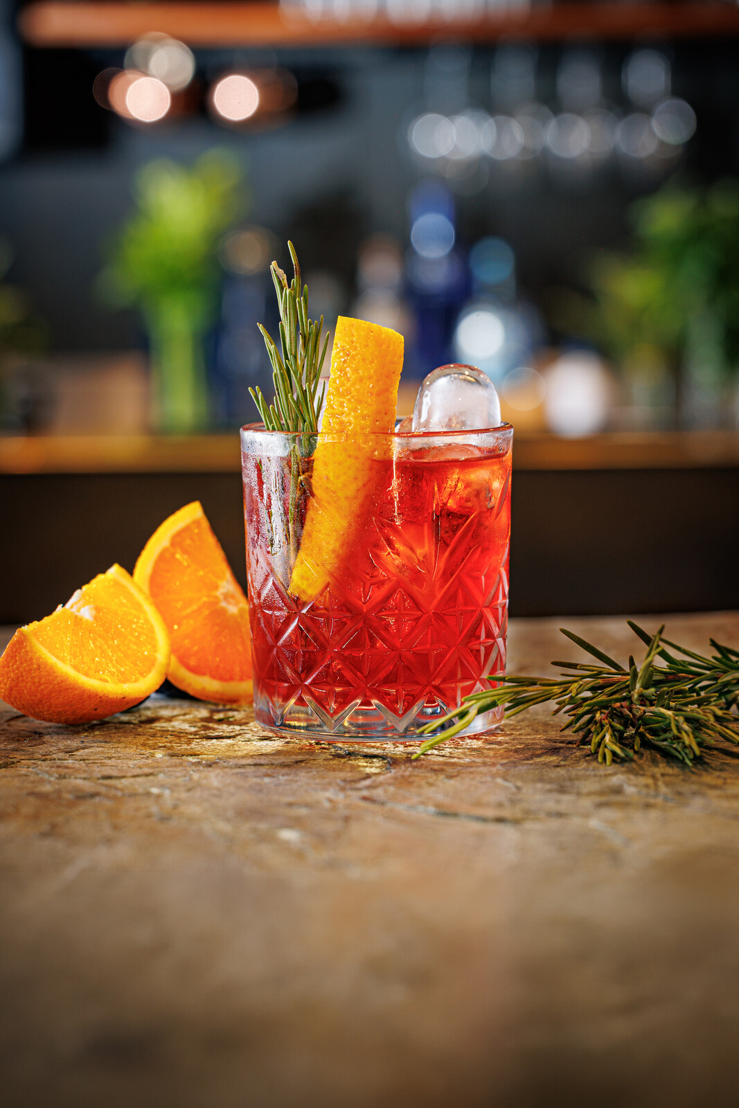 Cocktail rosso con fetta d arancia e rosmarino