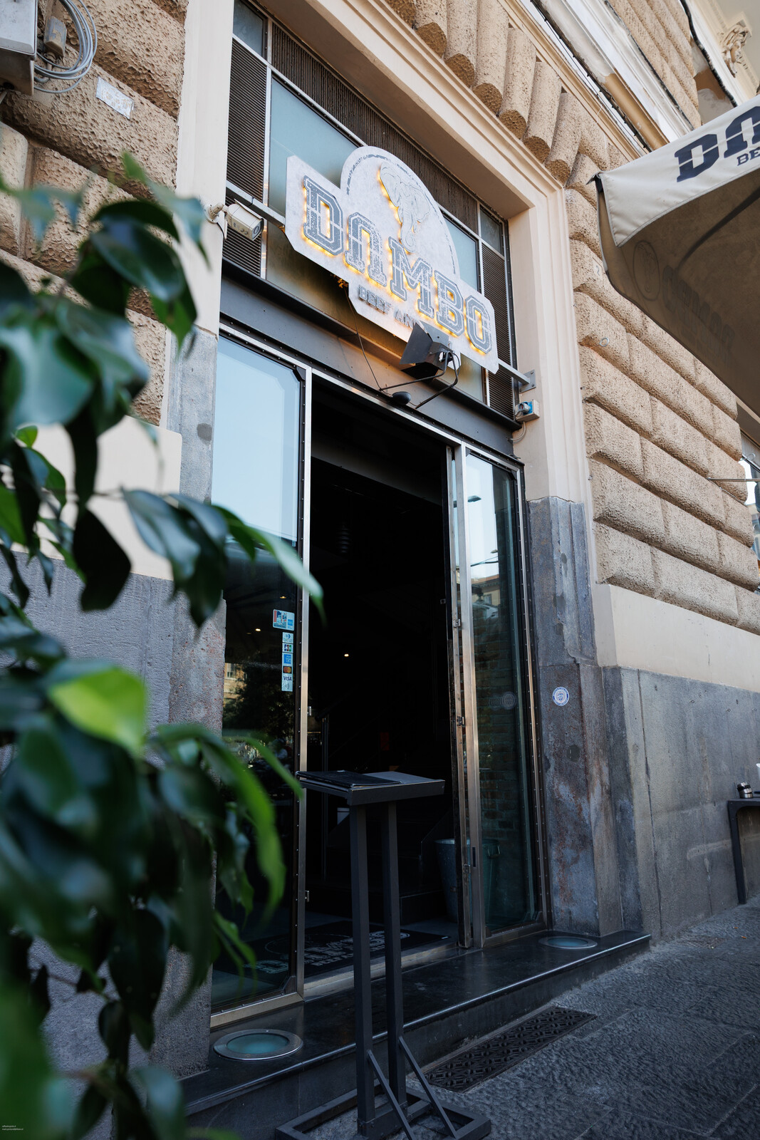 Ingresso del locale con le vetrate e le piante ai lati