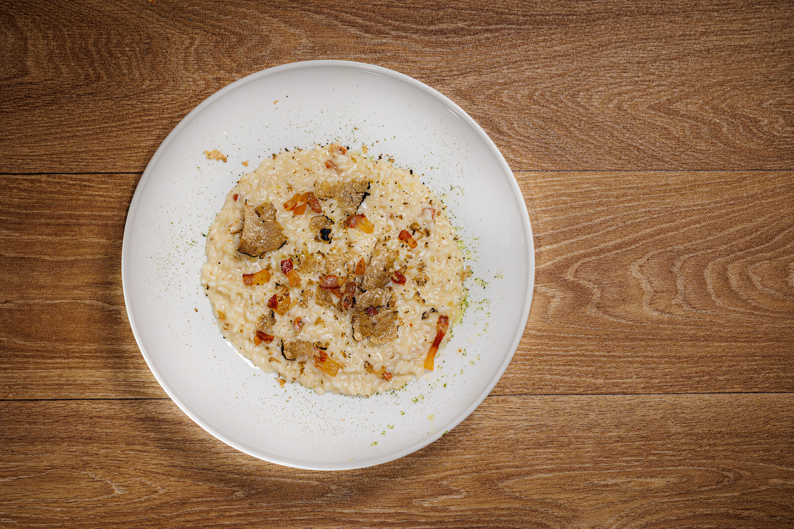 Risotto cremoso con granella tostata in piatto bianco