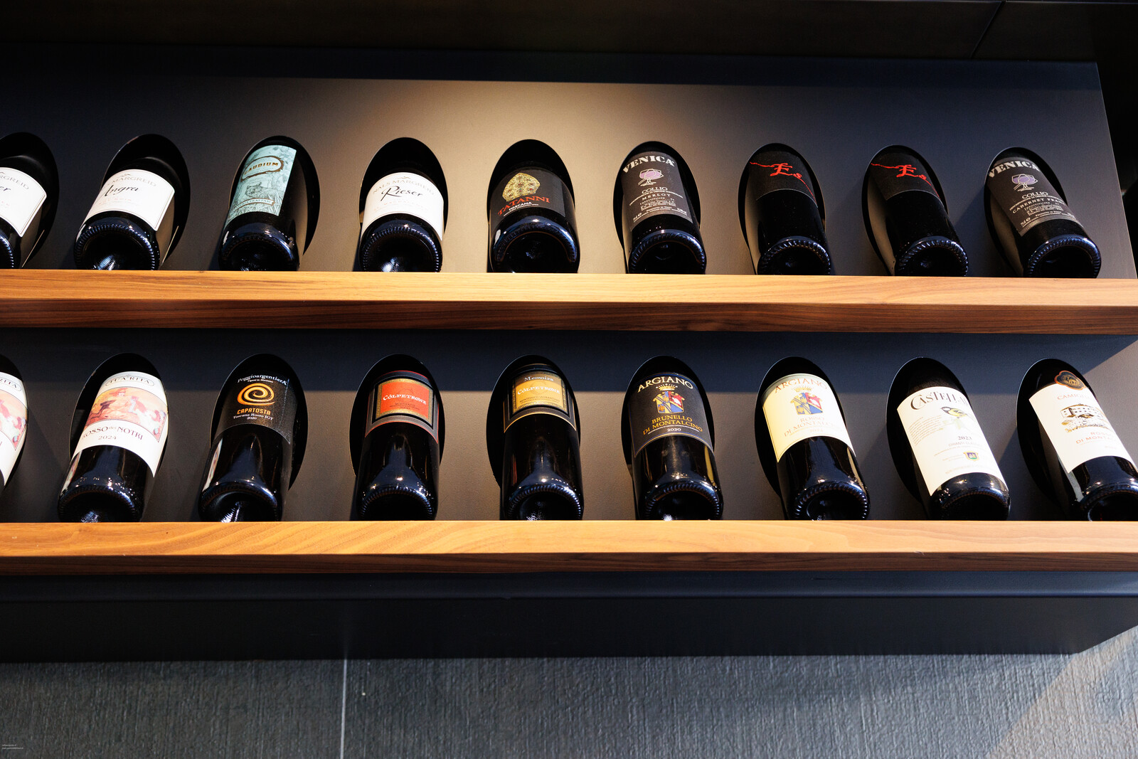 Bottiglie coricate sui ripiani di legno della cantina