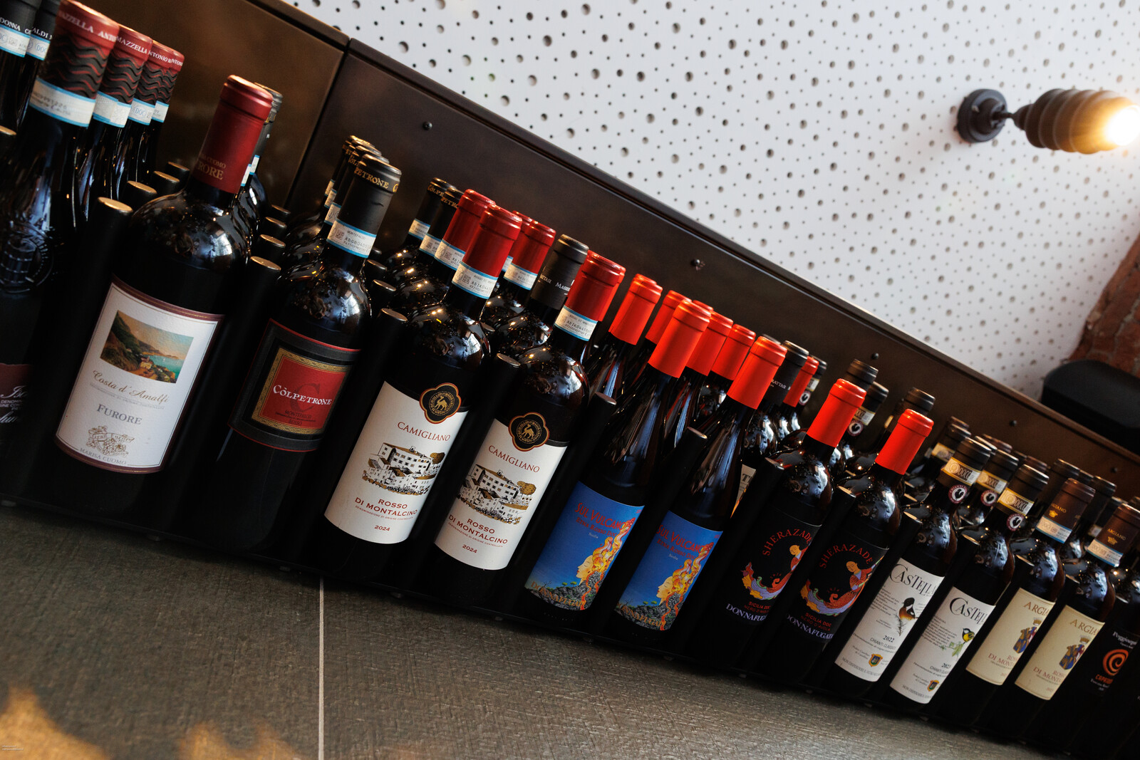 Bottiglie sui ripiani inclinati della cantina